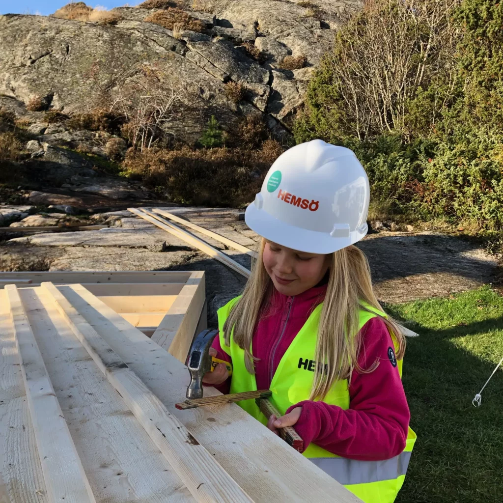 Flicka som snickrar med Hemsöhjälm och Hemsöväst