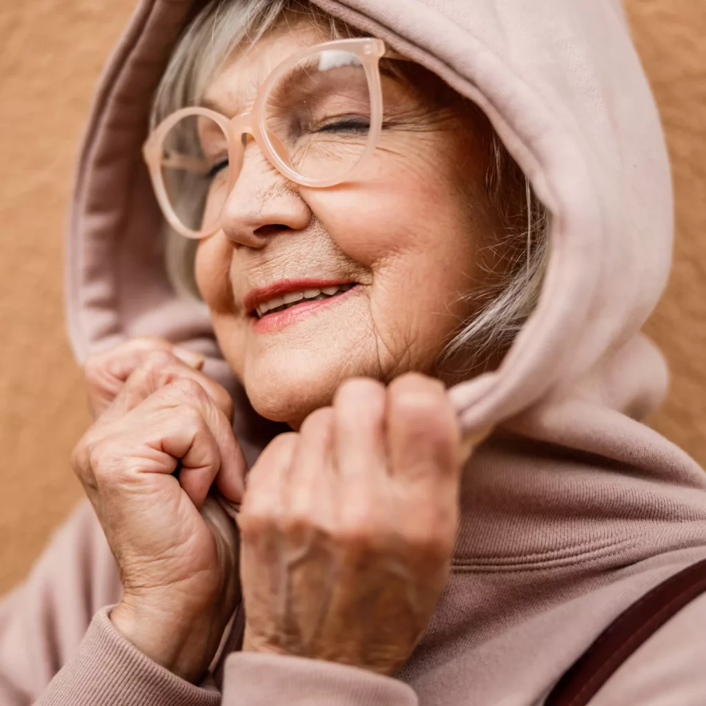 Äldre dam med glasögon som ser ut att trivas rätt bra