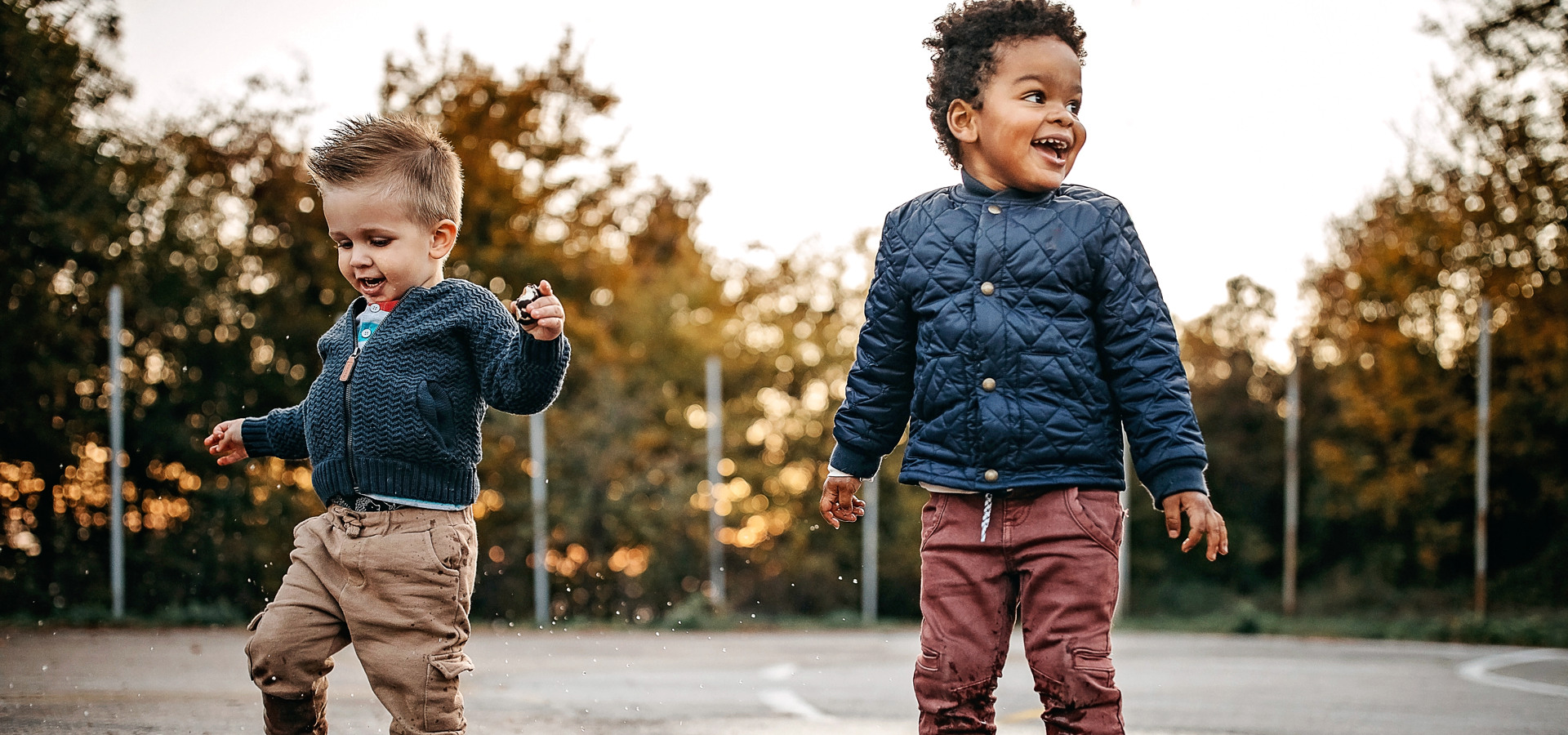 Två små pojkar leker i en vattenpöl